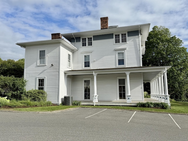 102 Beard Dr Unit 102, New Milford, CT 06776 - view of front of property featuring a chimney, a porch, central AC, and uncovered parking