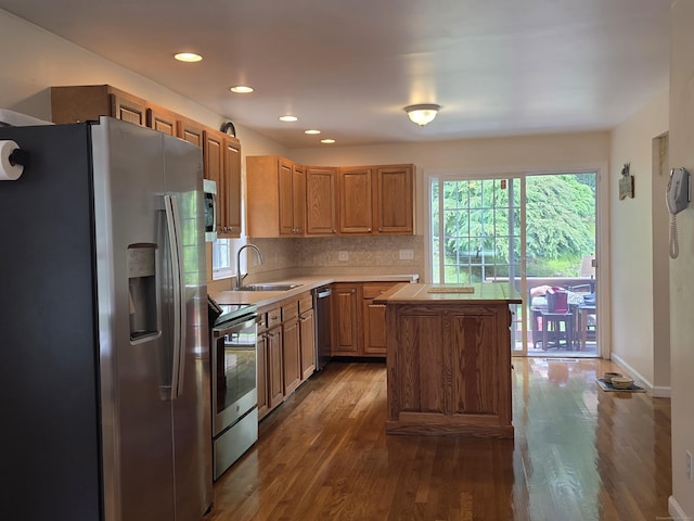 141 Grove St, Shelton, CT 06484 - kitchen with appliances with stainless steel finishes, a center island, light countertops, dark wood finished floors, and tasteful backsplash