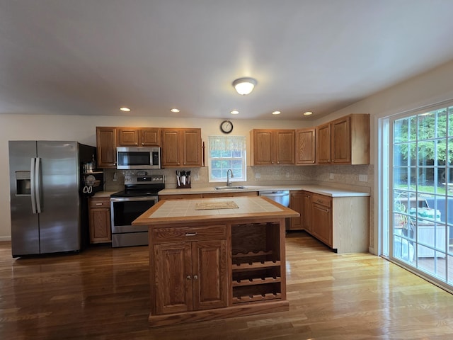 141 Grove St, Shelton, CT 06484 - kitchen with appliances with stainless steel finishes, tile countertops, wood finished floors, a center island, and recessed lighting