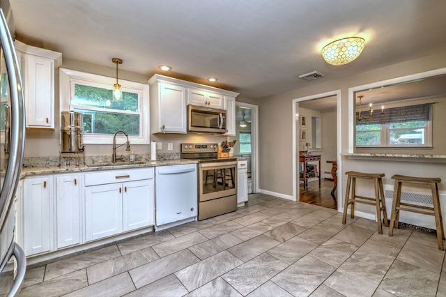 1690 Hartford Tpke, North Haven, CT 06473 - kitchen featuring stainless steel appliances, a sink, white cabinetry, light stone counters, and healthy amount of natural light