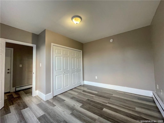 158 Martin St, Hartford, CT 06120 - unfurnished bedroom featuring a baseboard radiator, baseboard heating, wood finished floors, baseboards, and a closet
