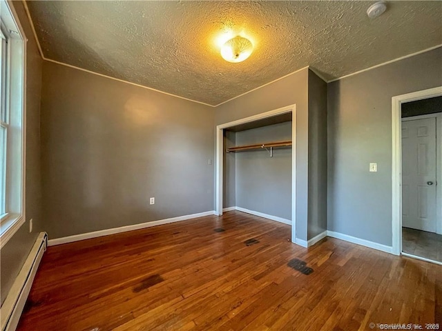 158 Martin St, Hartford, CT 06120 - unfurnished bedroom with baseboard heating, a textured ceiling, hardwood / wood-style flooring, a closet, and baseboards