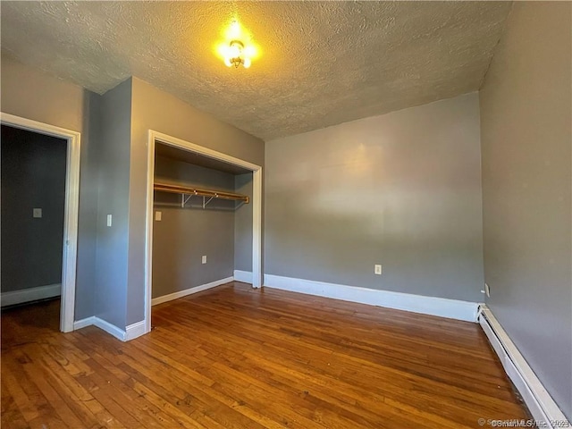 158 Martin St, Hartford, CT 06120 - unfurnished bedroom featuring a baseboard heating unit, a textured ceiling, hardwood / wood-style floors, a closet, and baseboards