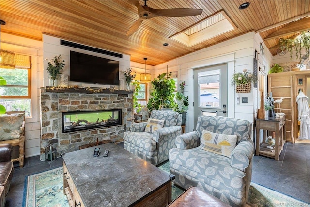311 Captain Thomas Blvd, West Haven, CT 06516 - living area featuring wood ceiling, ceiling fan, a stone fireplace, a skylight, and vaulted ceiling