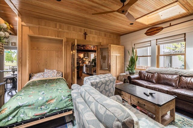 311 Captain Thomas Blvd, West Haven, CT 06516 - living area with wooden ceiling, wood walls, ceiling fan, and healthy amount of natural light