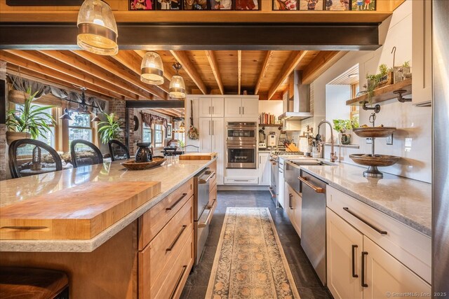 311 Captain Thomas Blvd, West Haven, CT 06516 - kitchen with stainless steel appliances, wooden ceiling with exposed beams, a sink, white cabinetry, and light stone counters