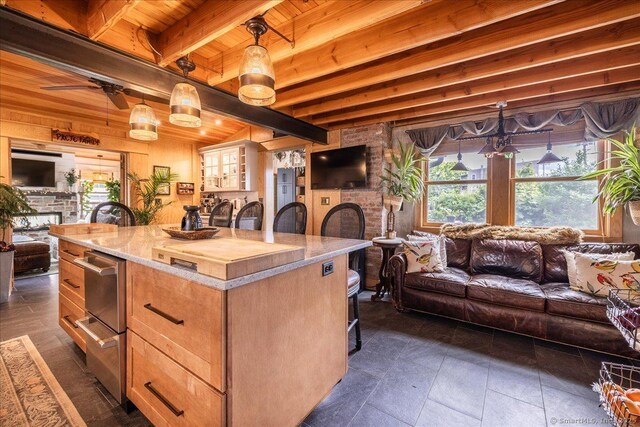 311 Captain Thomas Blvd, West Haven, CT 06516 - kitchen with open floor plan, a breakfast bar area, a fireplace, wooden ceiling with exposed beams, and plenty of natural light