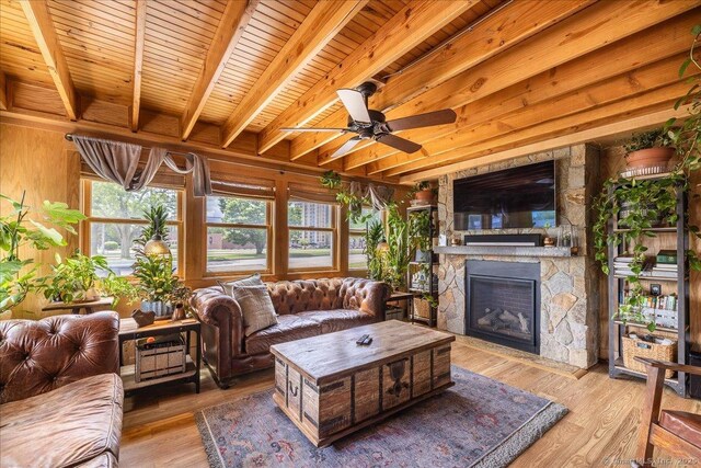311 Captain Thomas Blvd, West Haven, CT 06516 - living area with a stone fireplace, light wood finished floors, wood ceiling with exposed beams, a ceiling fan, and wood walls
