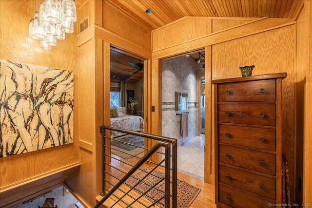 311 Captain Thomas Blvd, West Haven, CT 06516 - hallway with an upstairs landing, lofted ceiling, wooden ceiling, wooden walls, and a chandelier