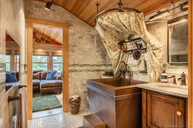 311 Captain Thomas Blvd, West Haven, CT 06516 - full bathroom with vaulted ceiling, wooden ceiling, vanity, tile patterned floors, and ensuite bath