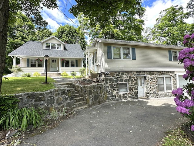 1188 Worthington Rdg, Berlin, CT 06037 - view of front facade with stone siding, roof with shingles, a front yard, and a porch