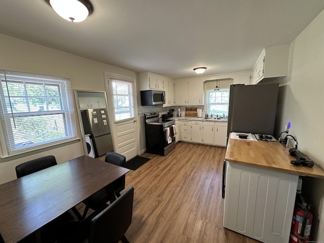 1188 Worthington Rdg, Berlin, CT 06037 - kitchen featuring appliances with stainless steel finishes, light wood finished floors, butcher block countertops, white cabinetry, and a sink