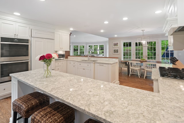 104 Cheesespring Rd, Wilton, CT 06897 - kitchen featuring appliances with stainless steel finishes, a peninsula, wood finished floors, a sink, and recessed lighting