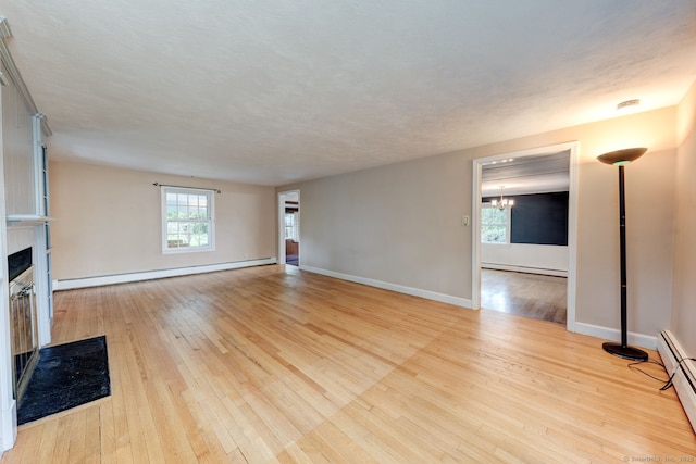 216 Belleview Ave, Southington, CT 06489 - unfurnished living room with baseboard heating, a baseboard heating unit, light wood-style floors, and a fireplace