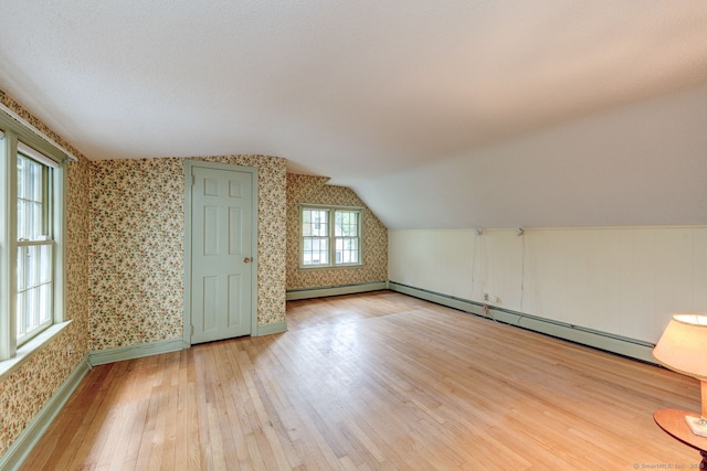 216 Belleview Ave, Southington, CT 06489 - bonus room featuring wallpapered walls, hardwood / wood-style floors, vaulted ceiling, baseboards, and baseboard heating
