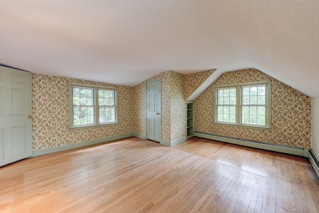 216 Belleview Ave, Southington, CT 06489 - bonus room with light wood-style floors, wallpapered walls, vaulted ceiling, a textured ceiling, and a baseboard heating unit