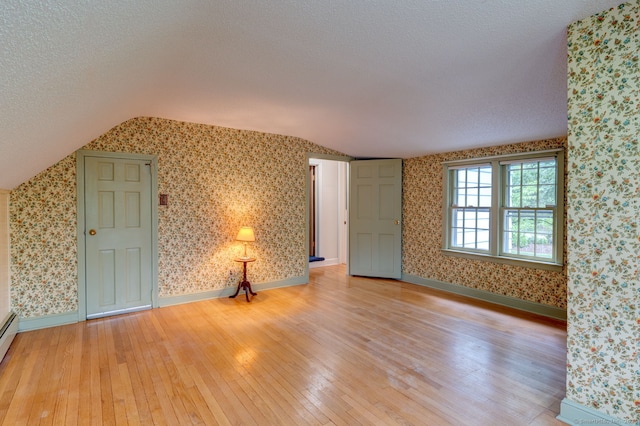 216 Belleview Ave, Southington, CT 06489 - additional living space with light wood-style floors, lofted ceiling, wallpapered walls, a textured ceiling, and baseboards