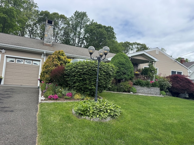 91 Lounsbury Rd, Trumbull, CT 06611 - view of front of house featuring a front lawn, an attached garage, a chimney, and asphalt driveway