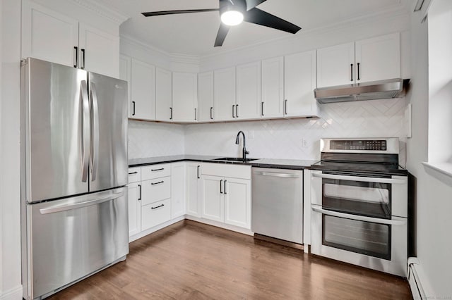 71 Mountain Laurel Dr Unit 71, Wethersfield, CT 06109 - kitchen featuring stainless steel appliances, under cabinet range hood, a sink, dark countertops, and baseboard heating