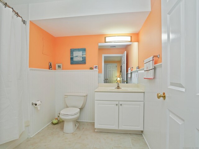 19 Isaacs St Apt 307, Norwalk, CT 06850 - full bathroom with a wainscoted wall, toilet, vanity, tile patterned floors, and curtained shower