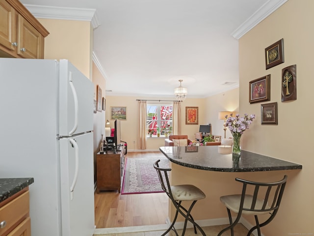 19 Isaacs St Apt 307, Norwalk, CT 06850 - kitchen featuring freestanding refrigerator, crown molding, light wood finished floors, a breakfast bar, and a peninsula
