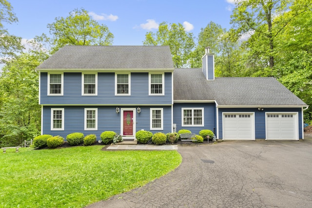 12 Colonial Heights Rd, East Haven, CT 06473 - colonial-style house with a chimney, an attached garage, asphalt driveway, and a front lawn