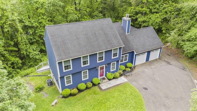 12 Colonial Heights Rd, East Haven, CT 06473 - view of front of property featuring a chimney, a garage, central AC, asphalt driveway, and a front lawn