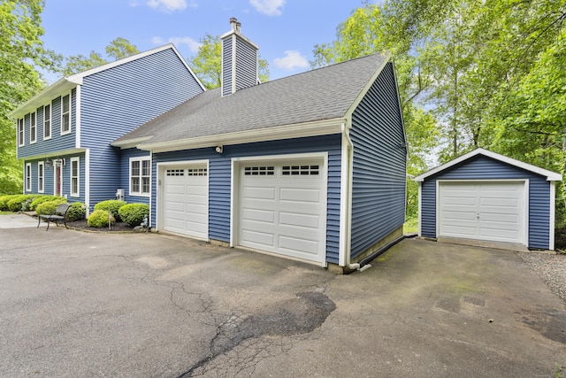 12 Colonial Heights Rd, East Haven, CT 06473 - view of home's exterior featuring a chimney, roof with shingles, and a garage