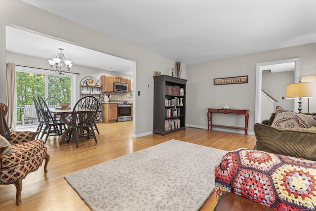 12 Colonial Heights Rd, East Haven, CT 06473 - living area featuring a chandelier, light wood-style flooring, and baseboards