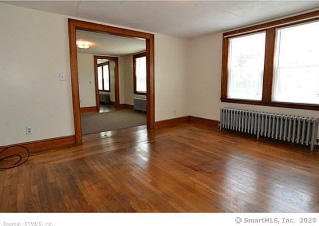 33 Silver St, Branford, CT 06405 - unfurnished room featuring radiator heating unit, radiator, hardwood / wood-style flooring, and baseboards