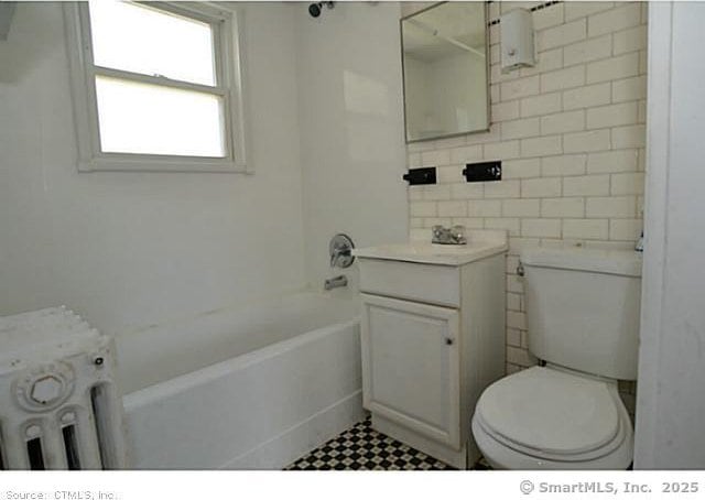33 Silver St, Branford, CT 06405 - bathroom featuring toilet, vanity, tile walls, radiator, and  shower combination
