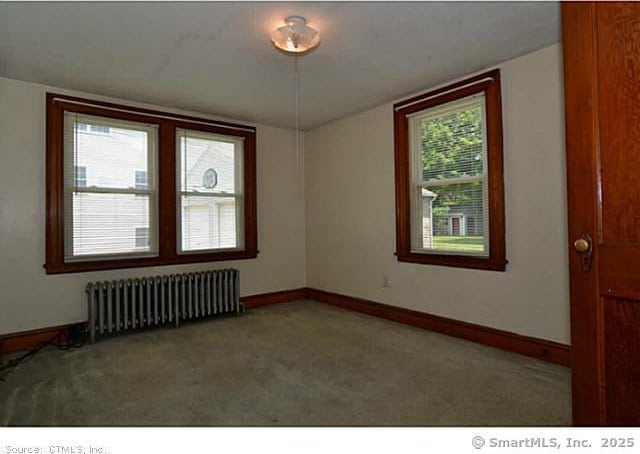 33 Silver St, Branford, CT 06405 - carpeted empty room with radiator heating unit and baseboards