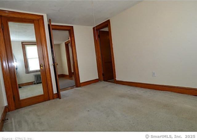 33 Silver St, Branford, CT 06405 - unfurnished room featuring radiator, light carpet, and baseboards