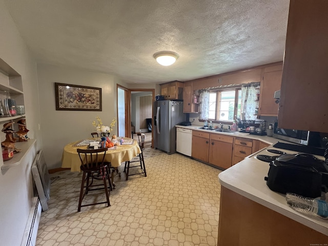 27 Eton Pl, New Britain, CT 06053 - kitchen with appliances with stainless steel finishes, light countertops, a textured ceiling, a baseboard radiator, and a sink