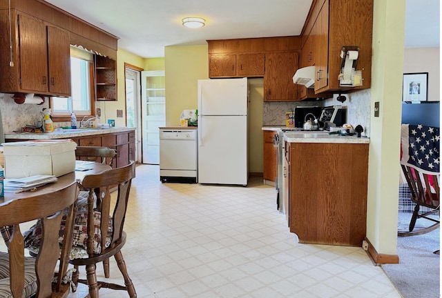 100 Arcadia Ave, Stratford, CT 06614 - kitchen with white appliances, under cabinet range hood, light countertops, and brown cabinets