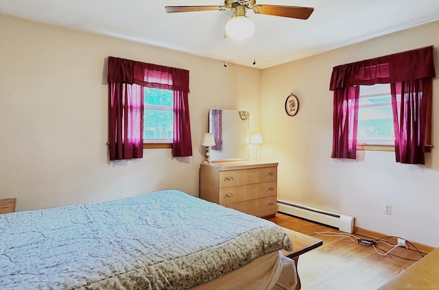 100 Arcadia Ave, Stratford, CT 06614 - bedroom with a baseboard radiator, wood finished floors, a ceiling fan, and baseboards
