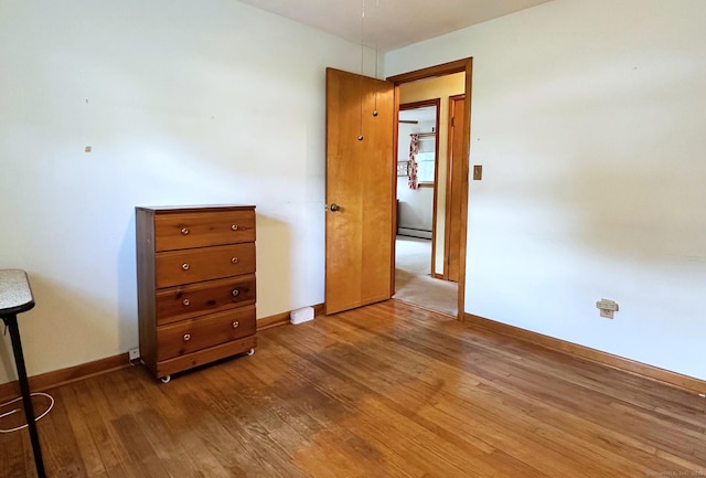 100 Arcadia Ave, Stratford, CT 06614 - unfurnished bedroom with baseboards, wood finished floors, and baseboard heating