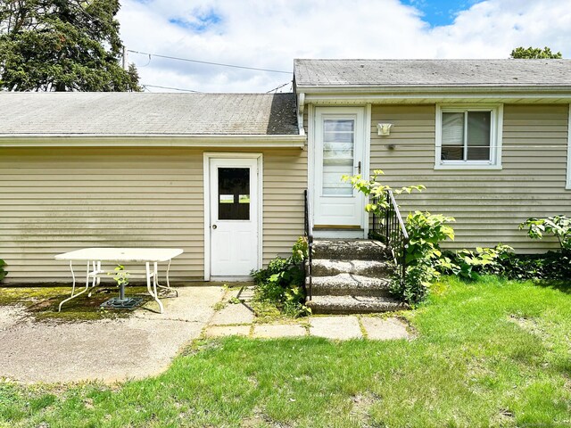 100 Arcadia Ave, Stratford, CT 06614 - entrance to property with a shingled roof, a lawn, and a patio area