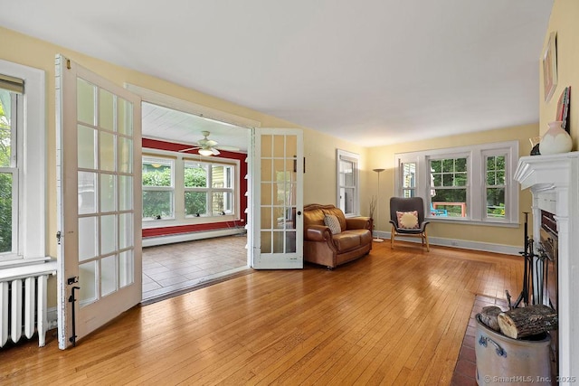 33 Bellevue Pl, Middletown, CT 06457 - living area featuring a baseboard heating unit, light wood-style floors, french doors, a fireplace, and ceiling fan
