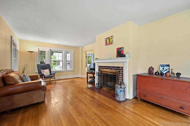 33 Bellevue Pl, Middletown, CT 06457 - living room featuring a brick fireplace, hardwood / wood-style flooring, arched walkways, and baseboards