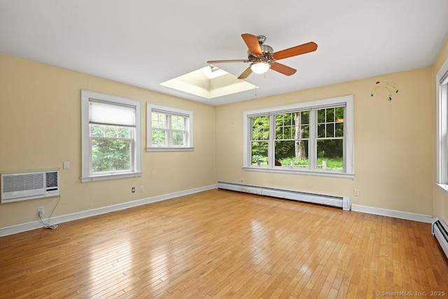 33 Bellevue Pl, Middletown, CT 06457 - spare room with baseboard heating, ceiling fan, a skylight, light wood-type flooring, and baseboards