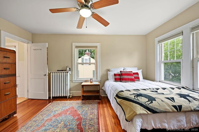 33 Bellevue Pl, Middletown, CT 06457 - bedroom featuring radiator heating unit, multiple windows, wood finished floors, and ceiling fan