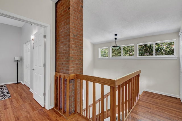 4 Pepperidge Ct Unit 4, Simsbury, CT 06070 - corridor featuring an upstairs landing, wood finished floors, a textured ceiling, and baseboards