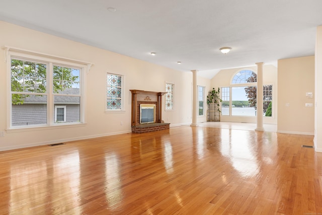 8 Wadsworth Ln, Waterford, CT 06385 - unfurnished living room featuring ornate columns, light wood finished floors, baseboards, a fireplace, and lofted ceiling