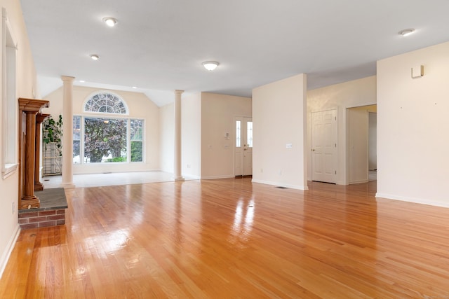 8 Wadsworth Ln, Waterford, CT 06385 - unfurnished living room featuring decorative columns, vaulted ceiling, light wood finished floors, and baseboards