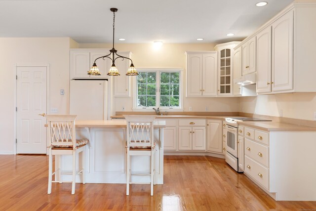 8 Wadsworth Ln, Waterford, CT 06385 - kitchen with white appliances, under cabinet range hood, white cabinetry, light wood-style floors, and recessed lighting