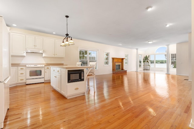 8 Wadsworth Ln, Waterford, CT 06385 - kitchen with white appliances, under cabinet range hood, healthy amount of natural light, white cabinetry, and recessed lighting