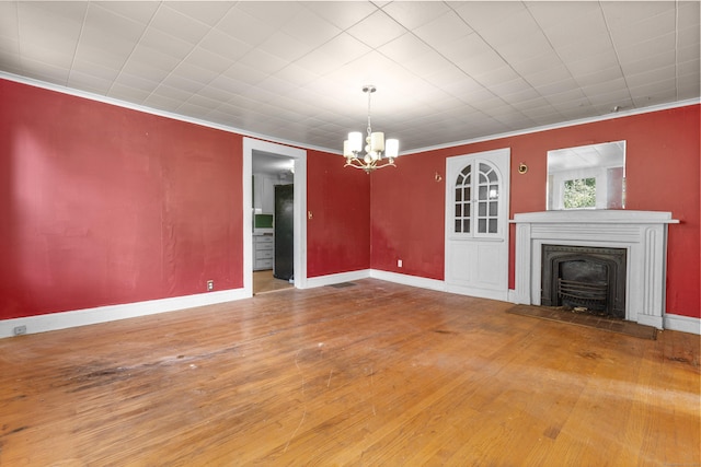 19 Elm St, Ansonia, CT 06401 - unfurnished living room featuring a chandelier, hardwood / wood-style flooring, a wood stove, crown molding, and baseboards