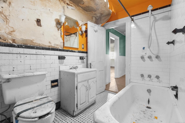 19 Elm St, Ansonia, CT 06401 - full bathroom featuring toilet, wainscoting, vanity, tile patterned floors, and shower / washtub combination