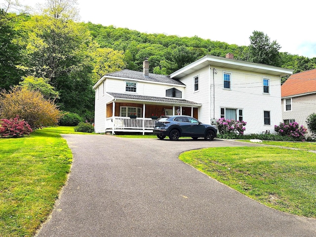 409 N Main St, Winchester, CT 06098 - view of front of house featuring a chimney, covered porch, a front lawn, and asphalt driveway